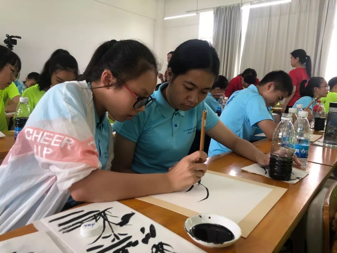 夏令營的書法體驗課程中，賀州營隊學員握著台灣學生的手書寫「福」字。