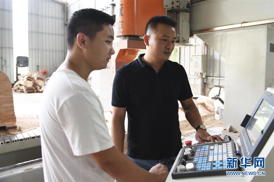 甘秀平（右）與技術人員在廠房裡調試機器