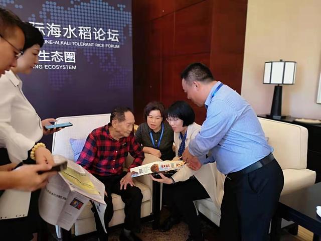 欽州市李磊岩副市長向袁隆平院士介紹海紅米大米包裝產品。