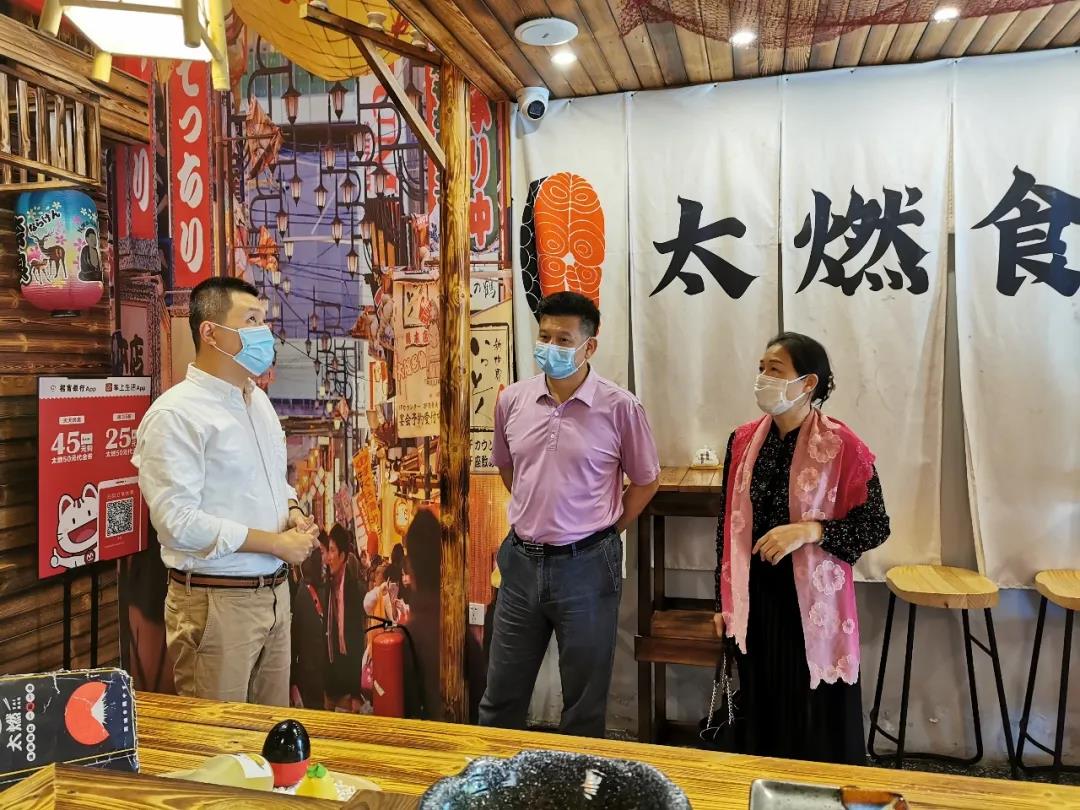 廣西台辦副主任丘德彬（中）與太燃台式日料店負責人陳先生（左）交流。