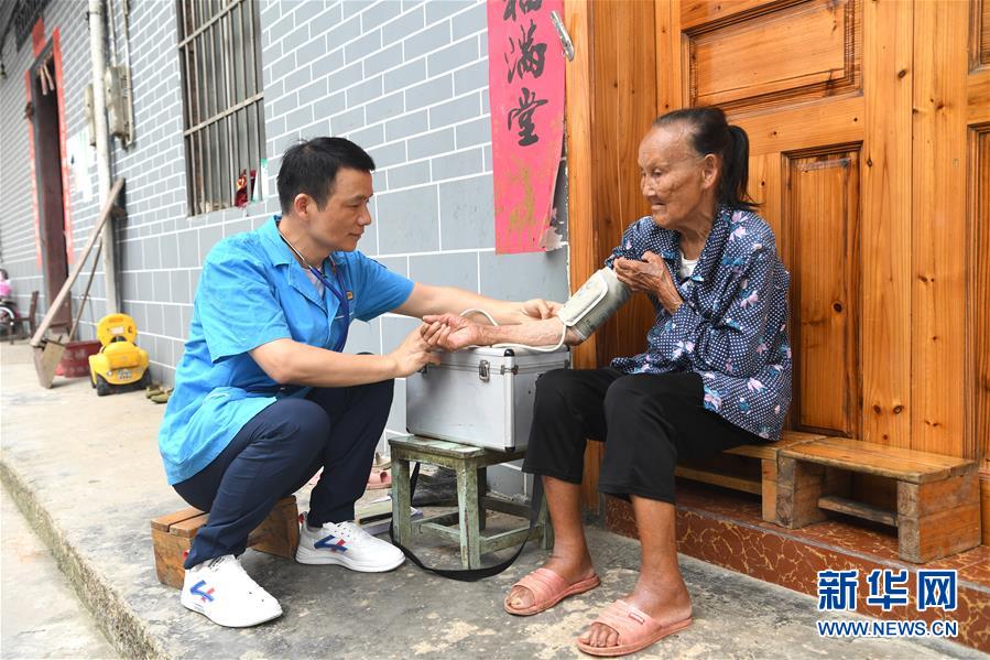 在長垌村出診的陶雷（左）給一名瑤族群眾測量血壓。