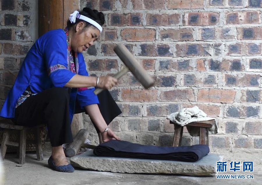 侗繡技藝傳承人楊甜在錘打製作侗族服飾的布料。
