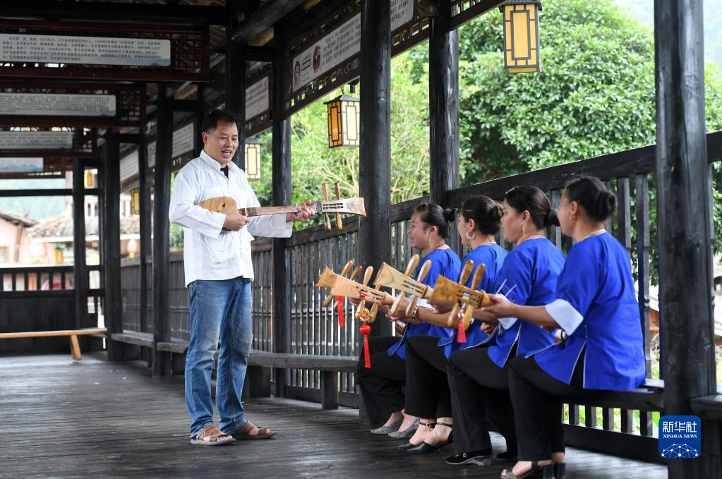 楊龔（左一）和當地村民一起彈唱侗族琵琶歌。