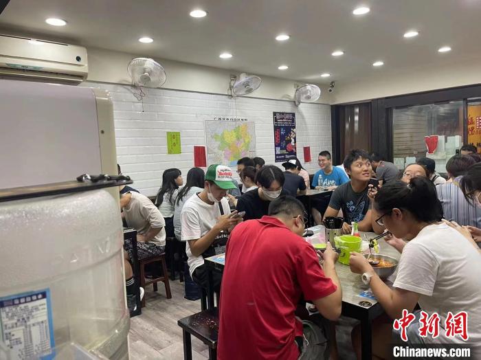 眾多食客在台北的柳州螺螄粉店內品嚐柳州螺螄粉。