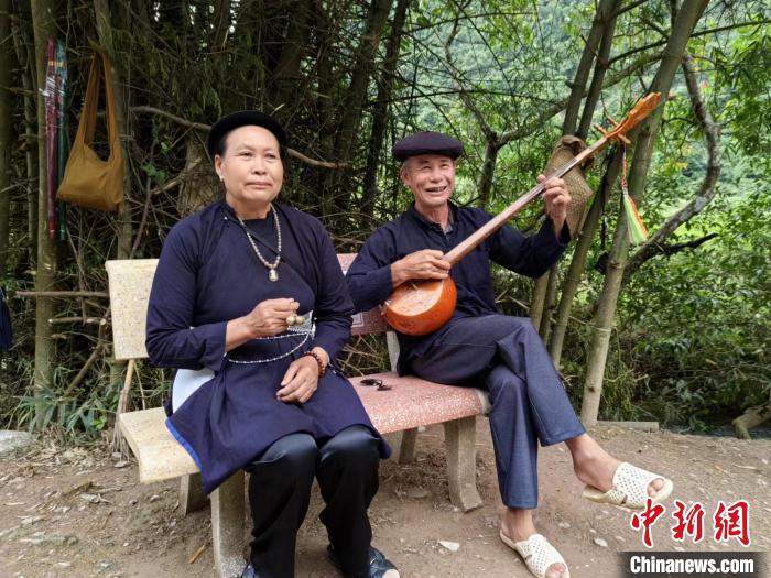 越方一側悠閒彈奏民族樂器的越南老人。