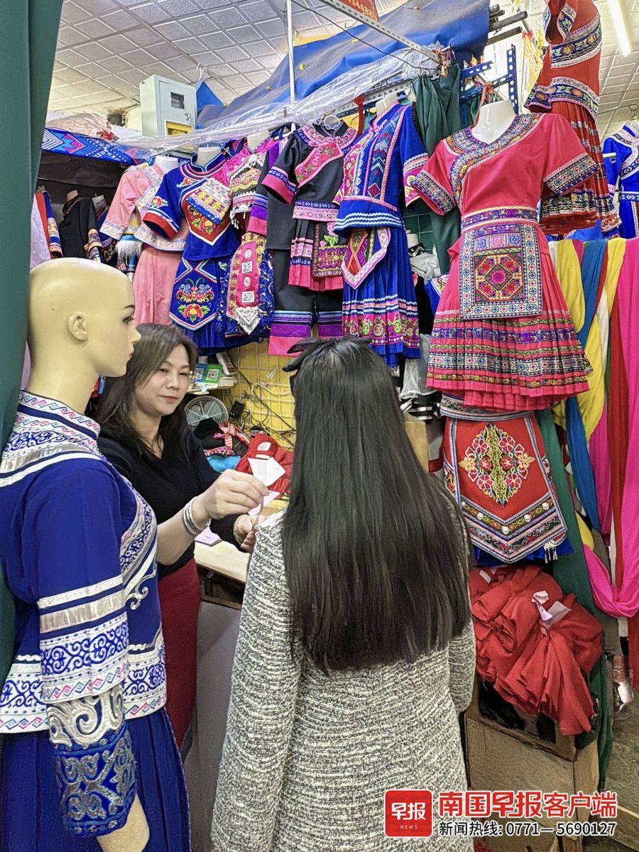 一商戶給顧客量身訂做民族服飾。