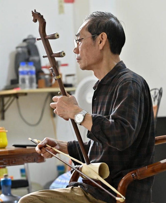 為一把馬骨胡試音。 為一把馬骨胡試音。
